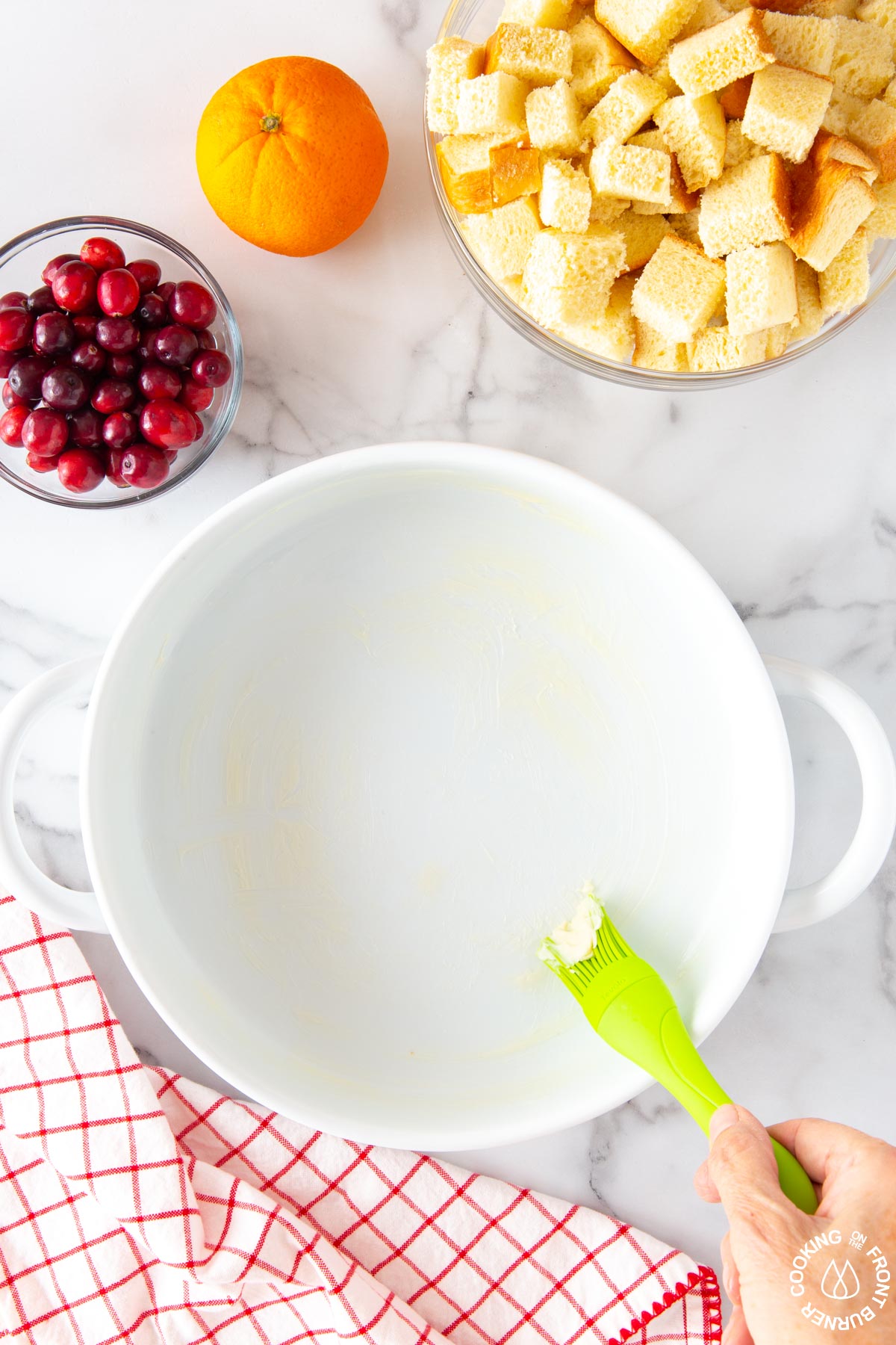 buttering a round white casserole dish