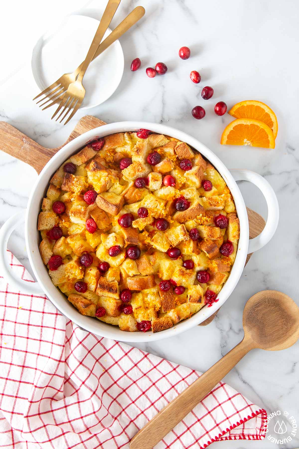 a white baking dish with orange cranberry french toast bake