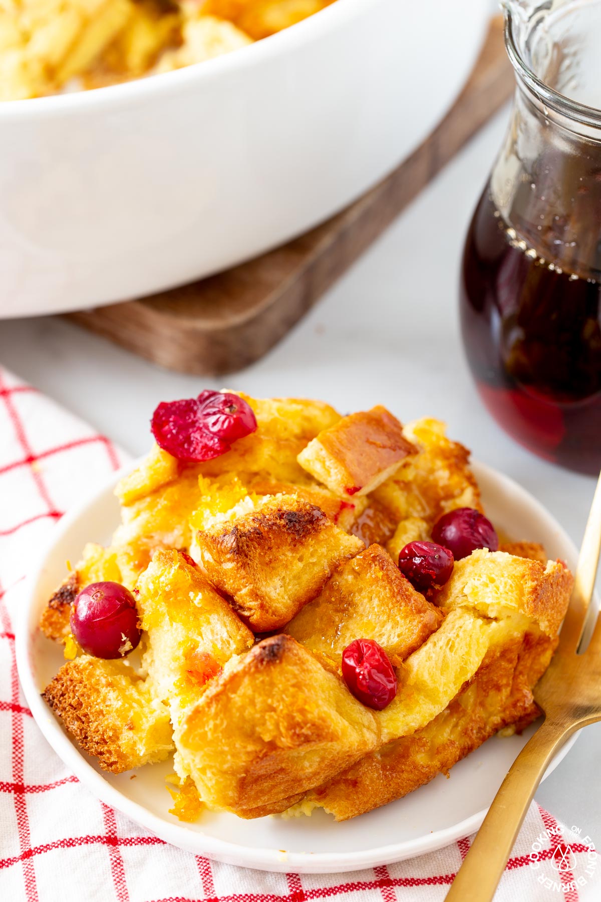 a slice of orange cranberry french toast bake on a white dish