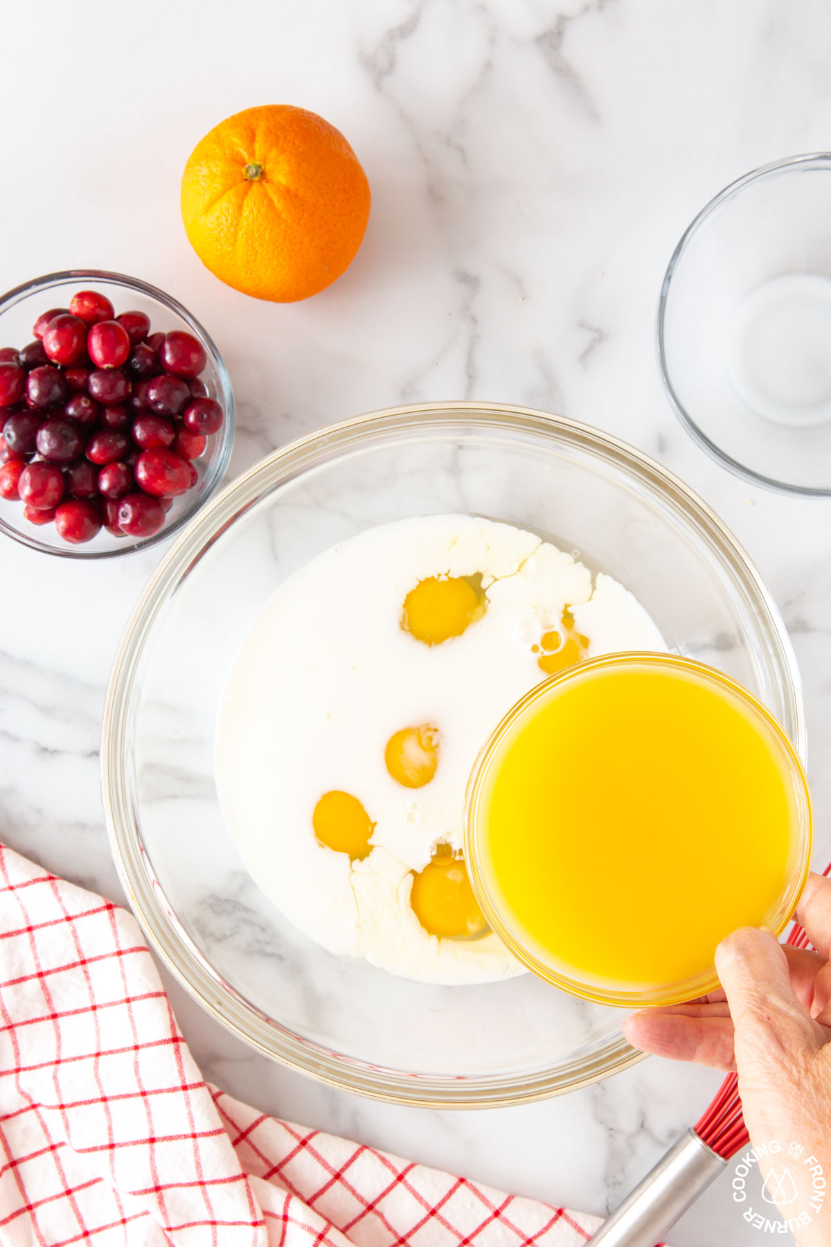 milk and eggs in a bowl pouring in OJ