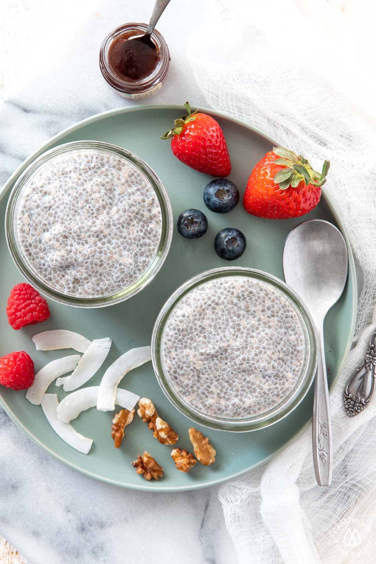 2 canning jars with chia pudding on a green plate