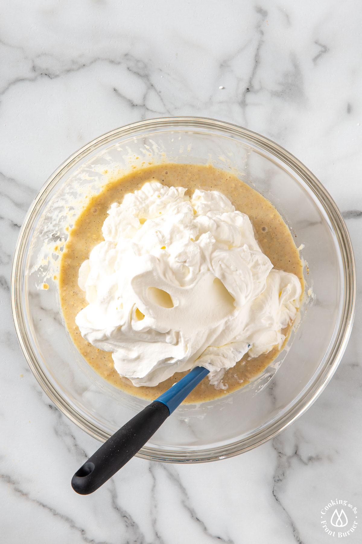 whipped cream on top of cereal mixture in a clear bowl