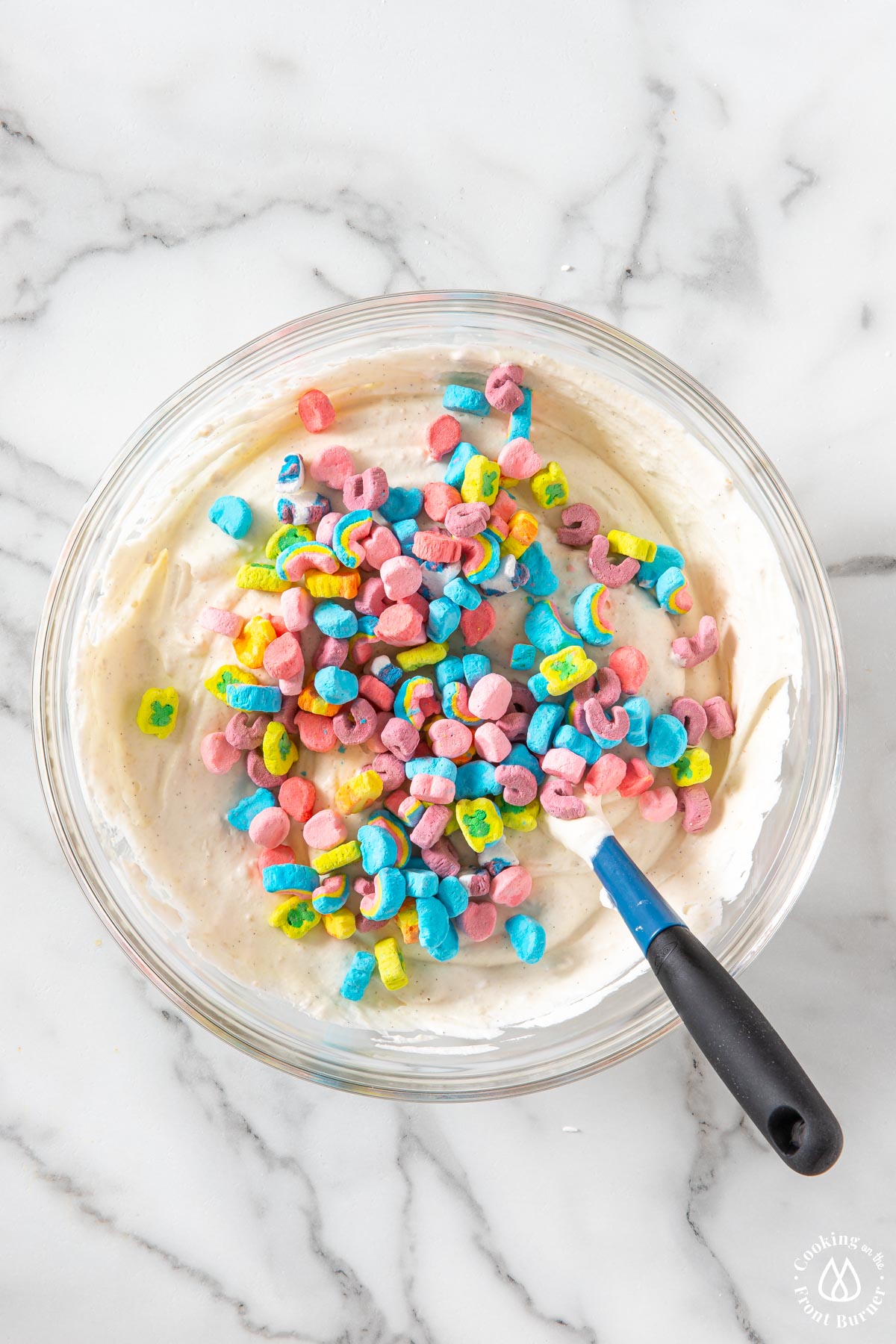 lucky charms on top of a whipped cereal cereal mixture in a clear bowl