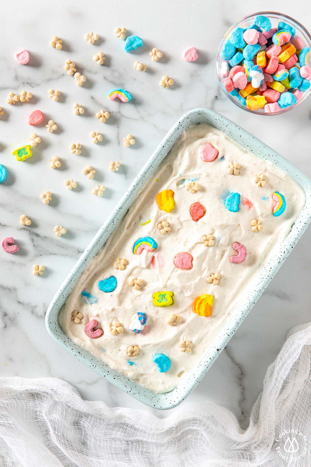loaf pan with ice cream mixture topped with lucky charm marshmallows