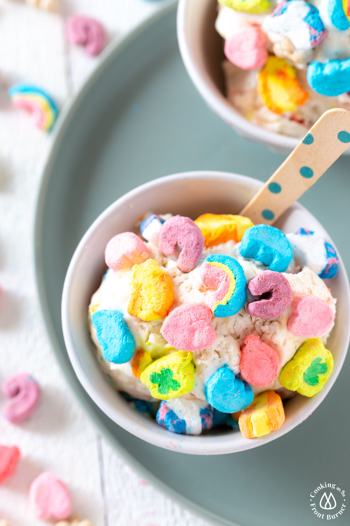 white bowl on green plate; bowl has lucky charm ice cream