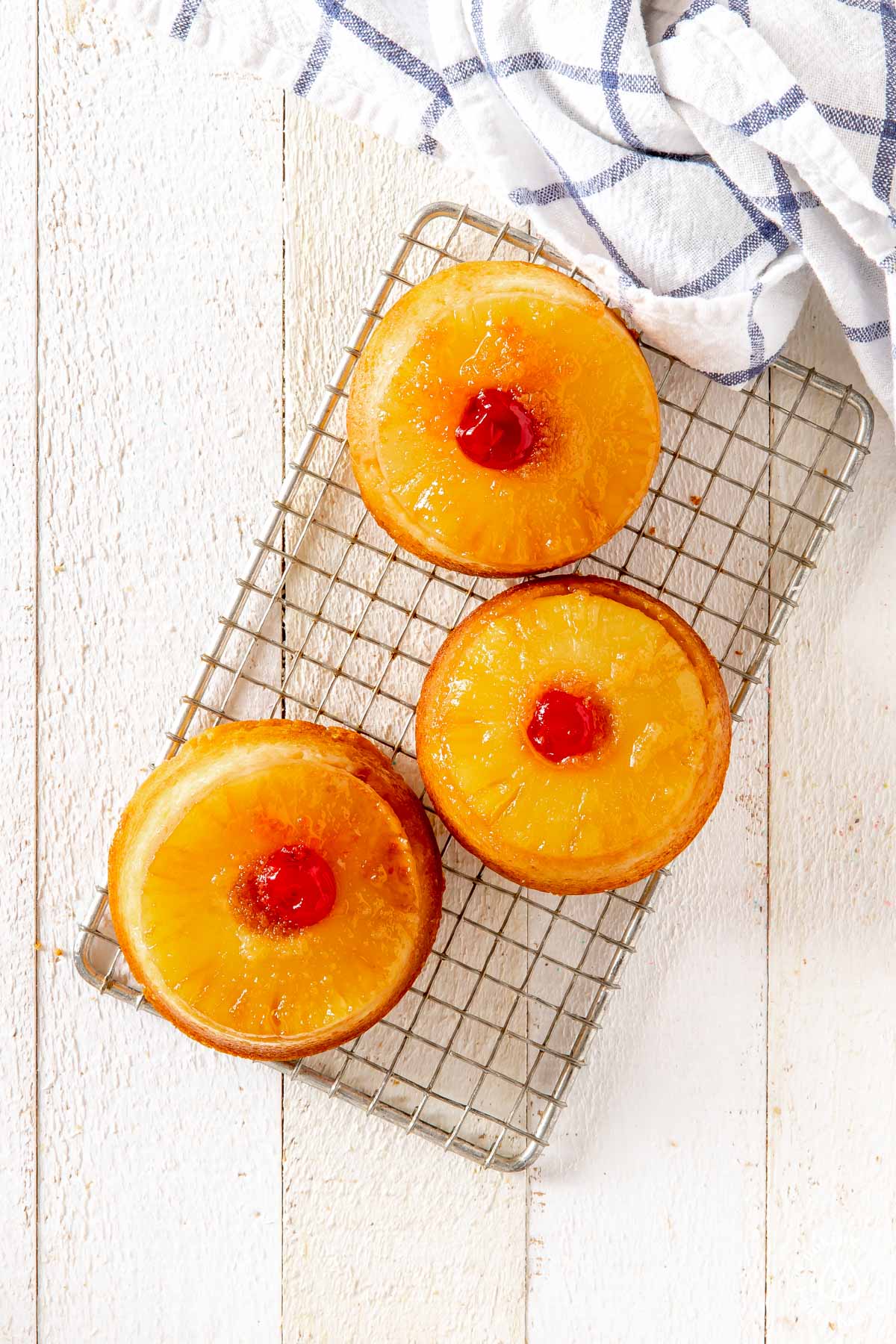 3 pineapple upside down cakes on a wire rack