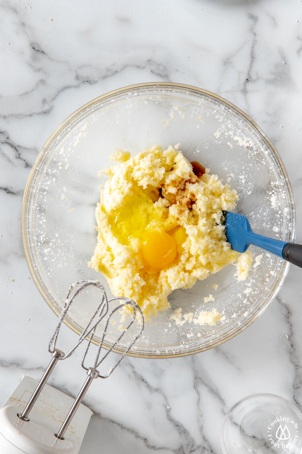 clear bowl with cream butter mixture and adding a egg