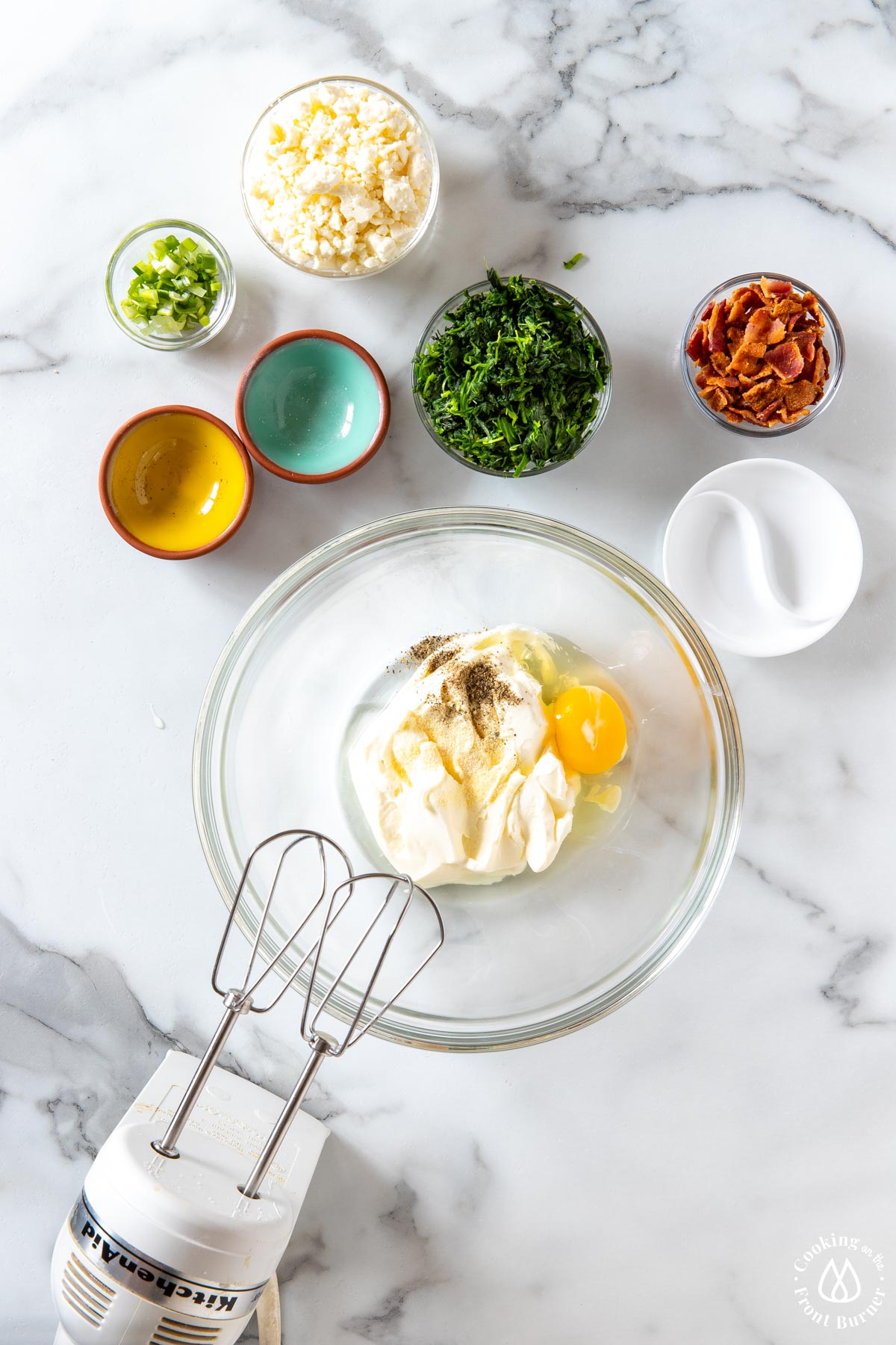 a bowl with cream cheese, garlic powder, pepper and egg