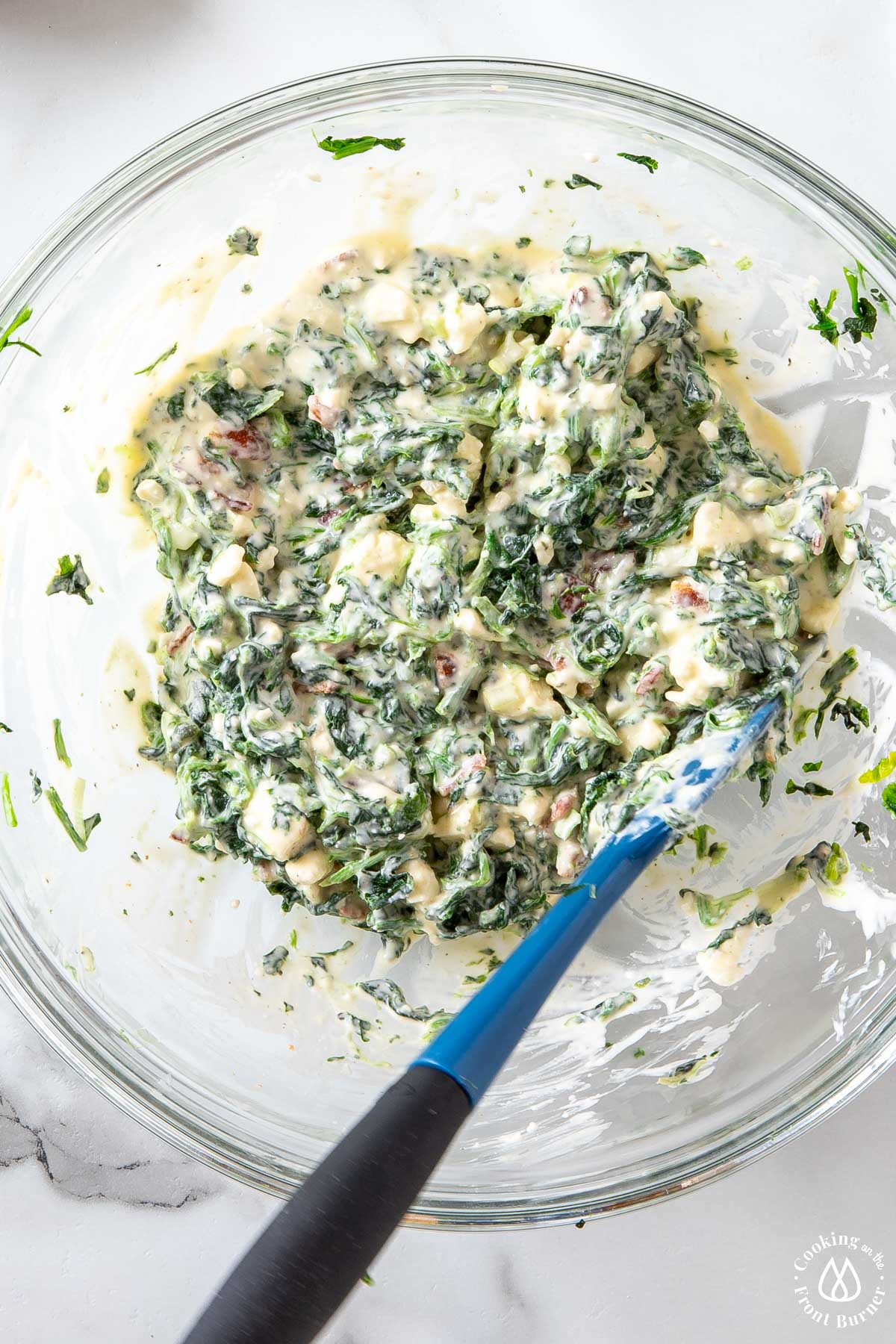 a feta, spinach mixture in a clear bowl