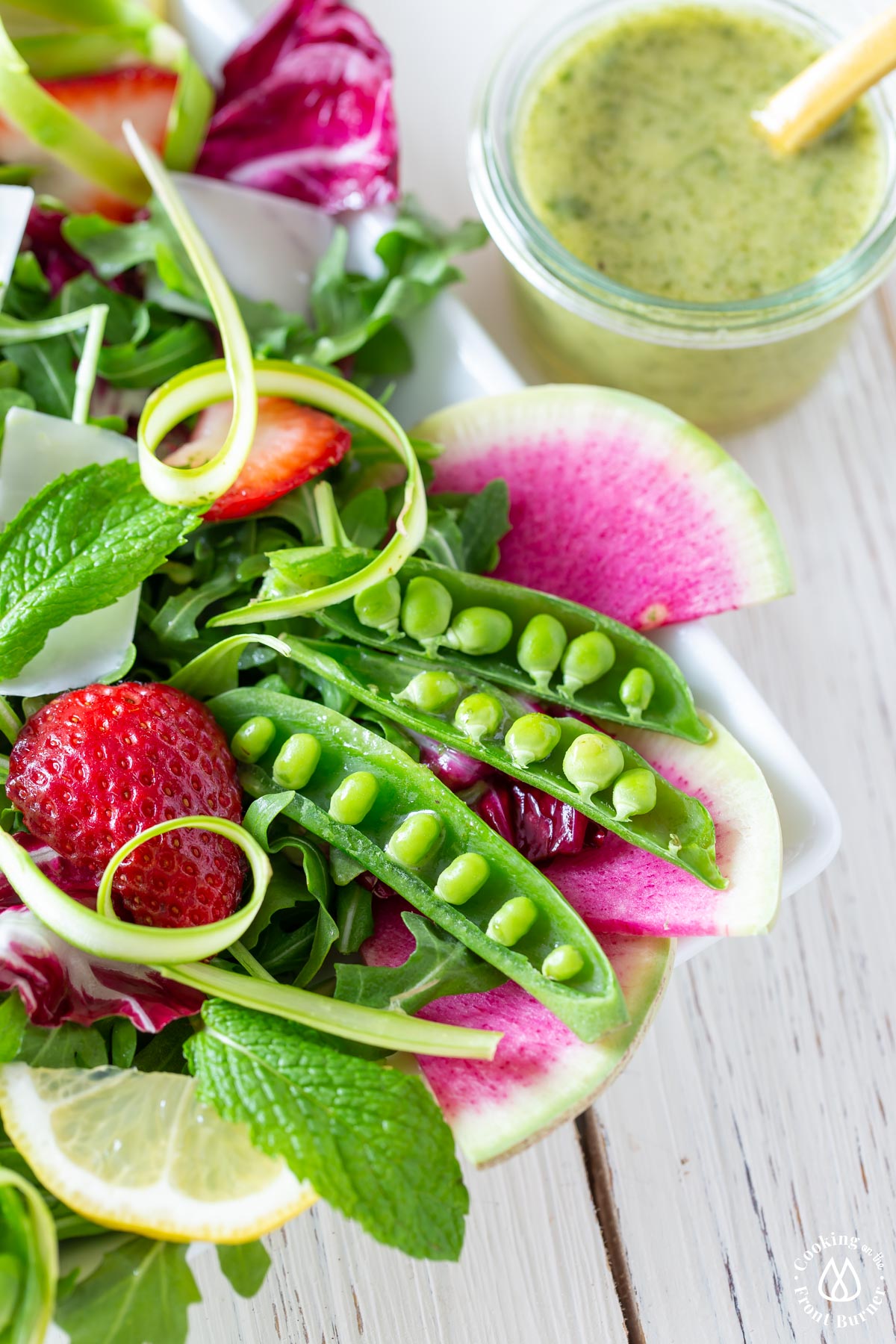 white dish with peas, strawberries watermelon radishes