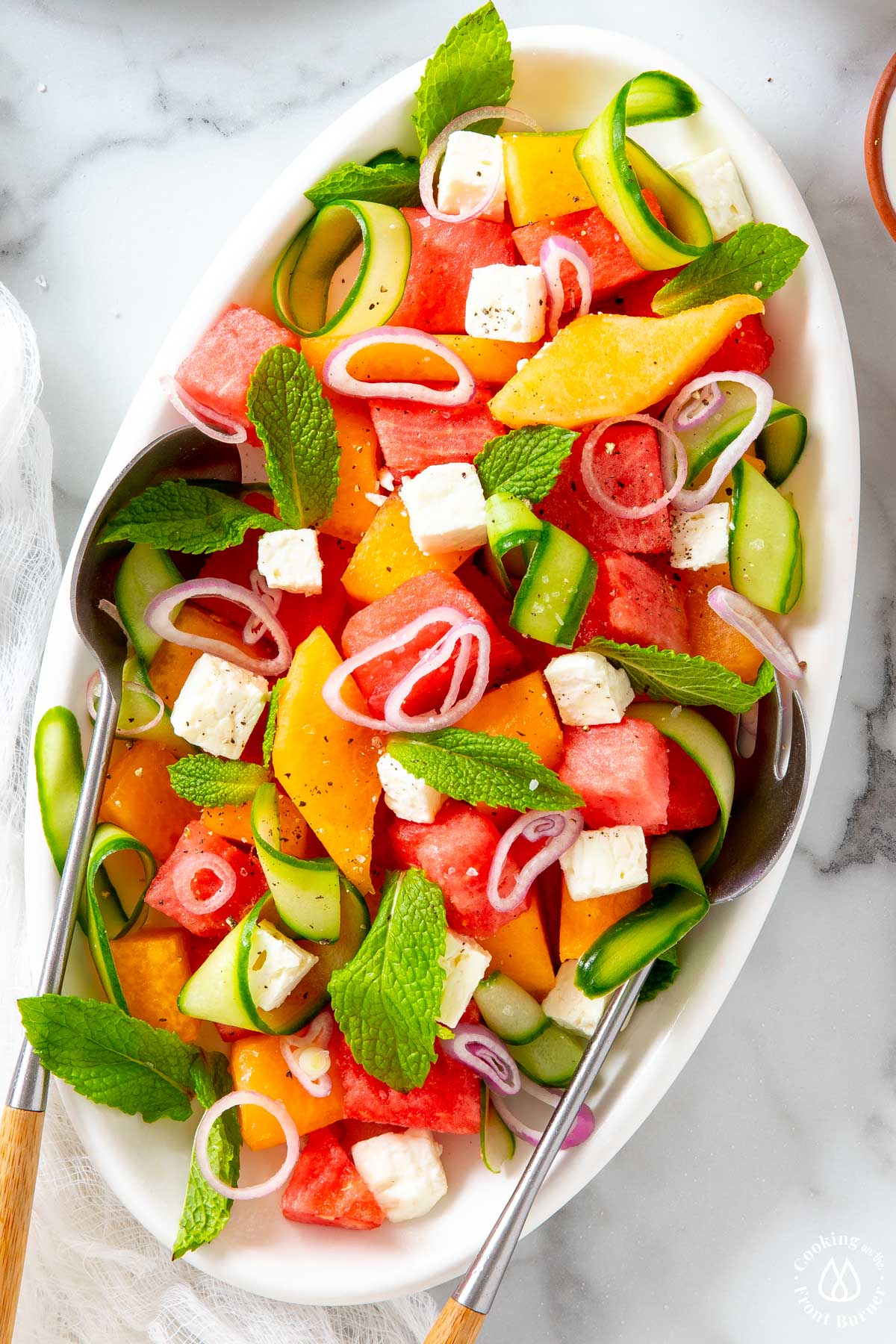 mixed melon, cucumber, feta on a white plate