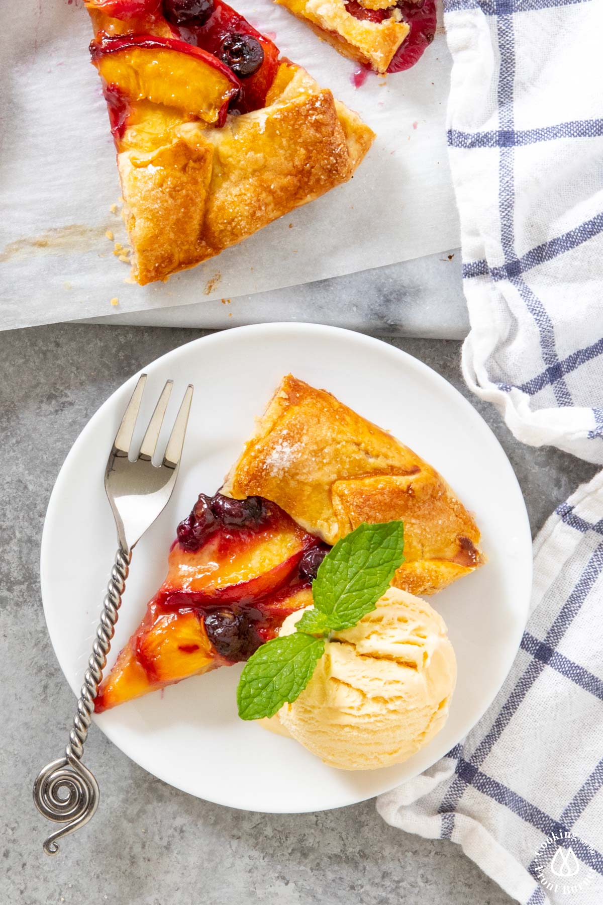 a slice of galette on a white plate with vanilla ice cream