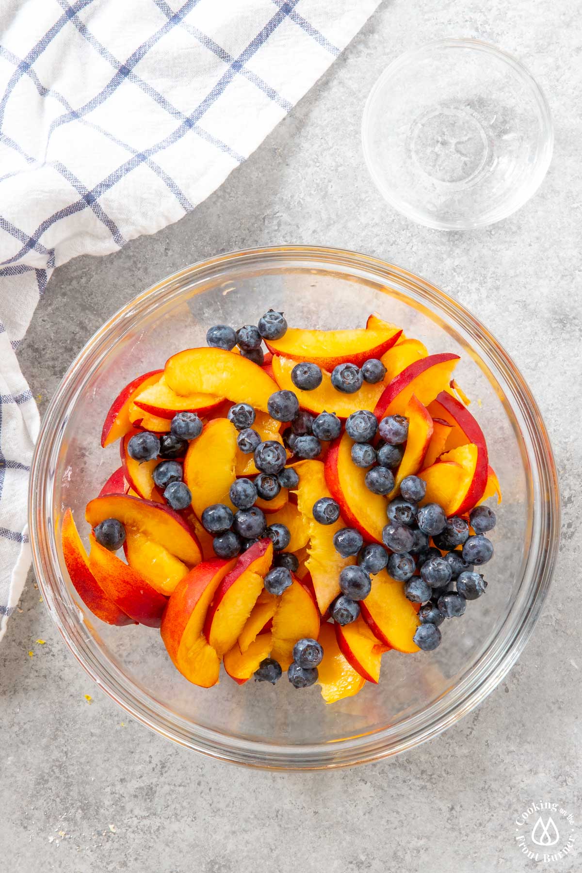 sliced peaches and blueberries in a clear bowl