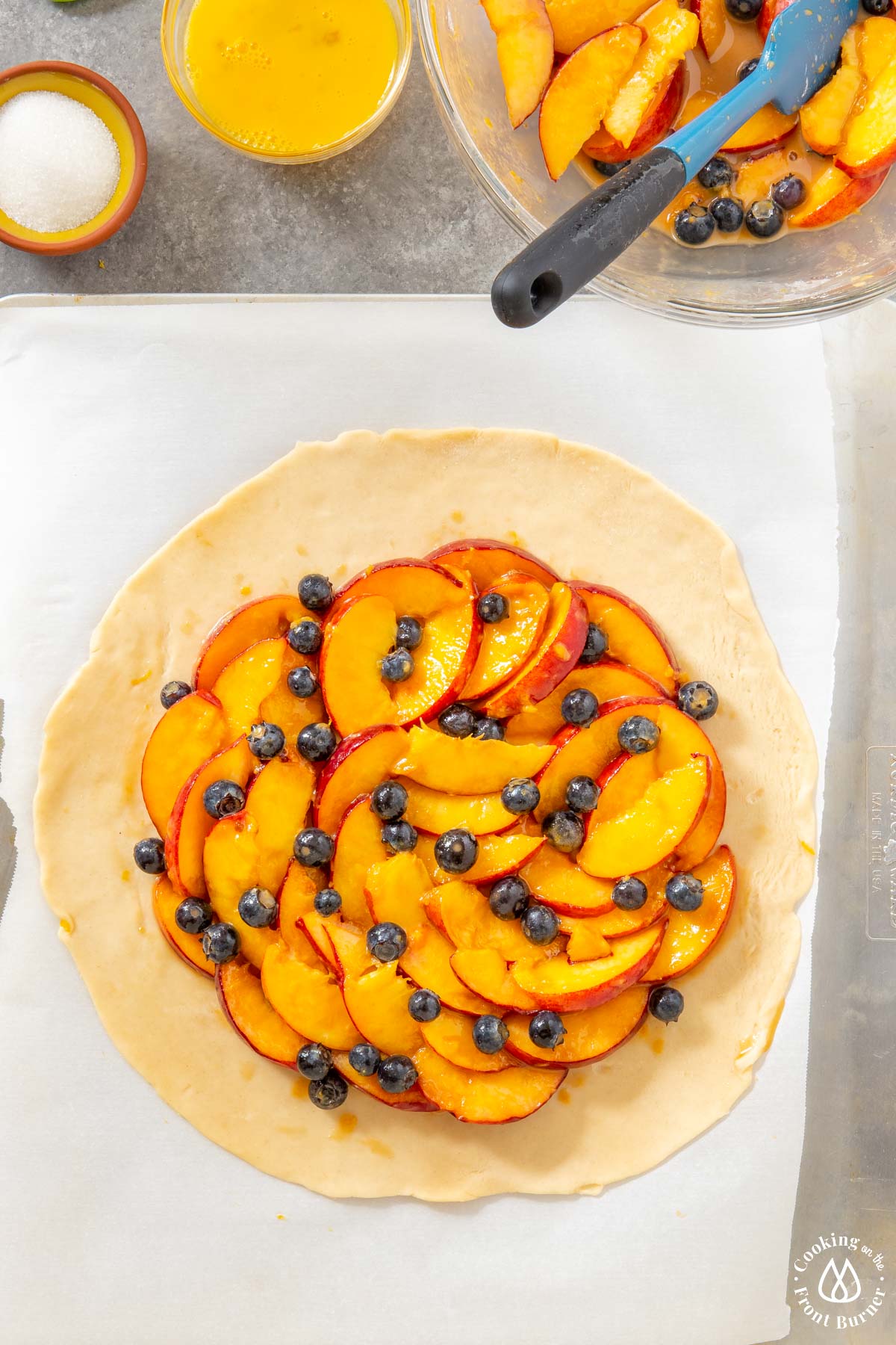 pie crust topped with fresh peaches and blueberries