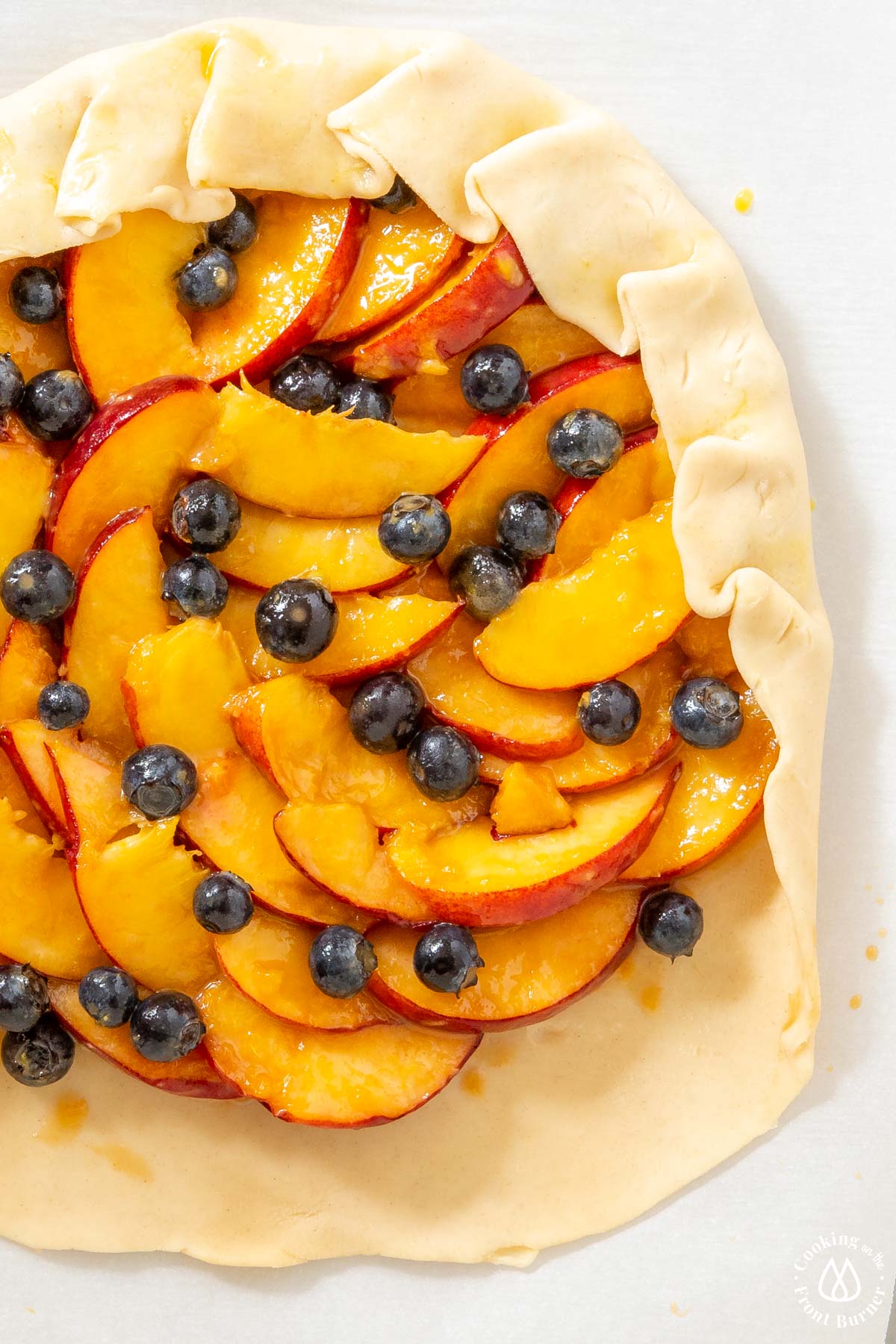 pie crust with fruit and crimping the edges up over the fruit