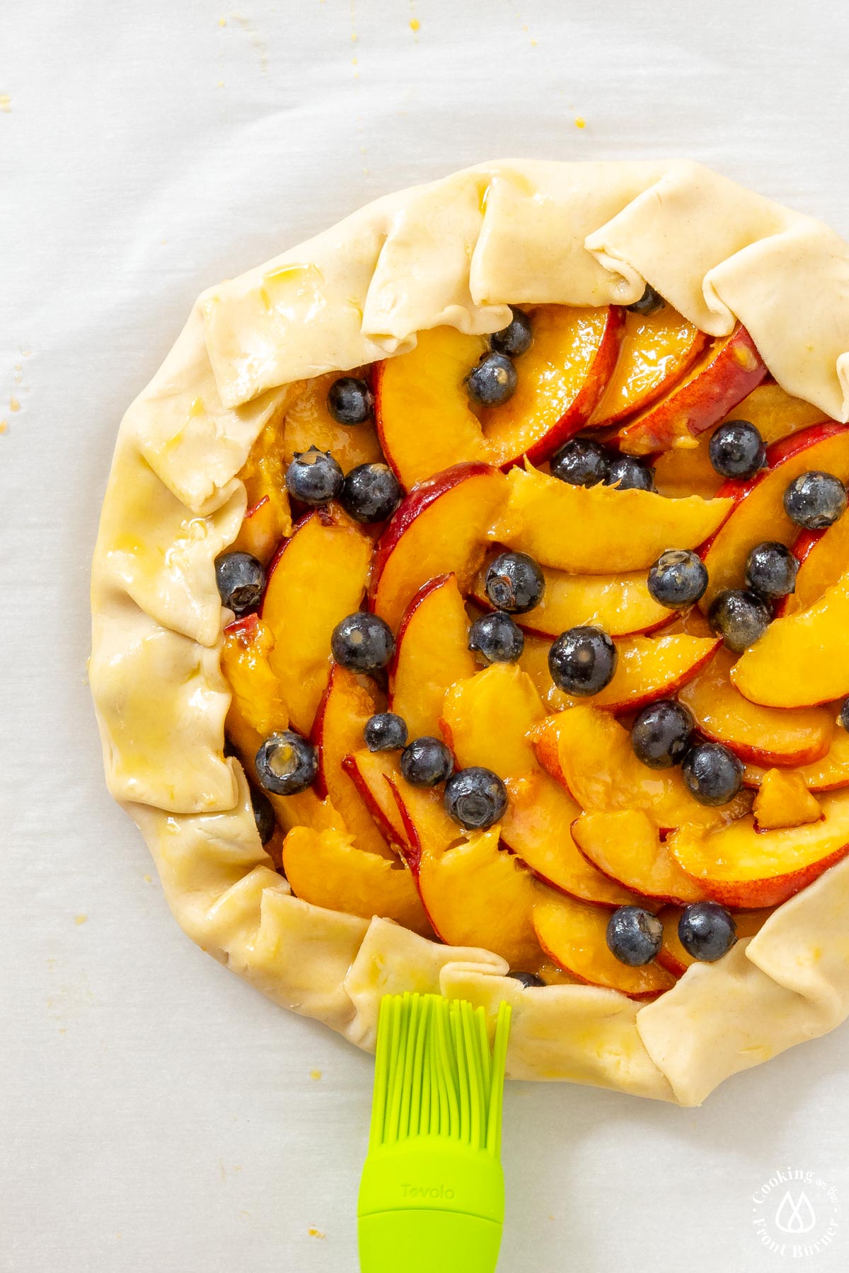 brushing egg wash over pie crust