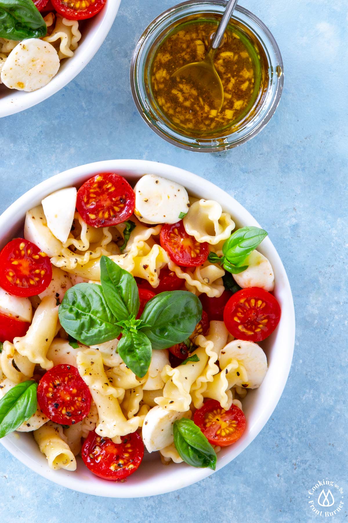 round white bowl with caprese salad; jar of viniagrette