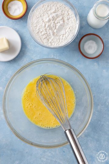 a clear bowl with whisked eggs