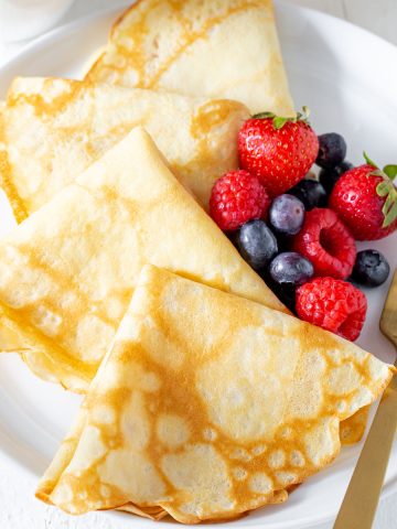 4 crepes on a plate with berries