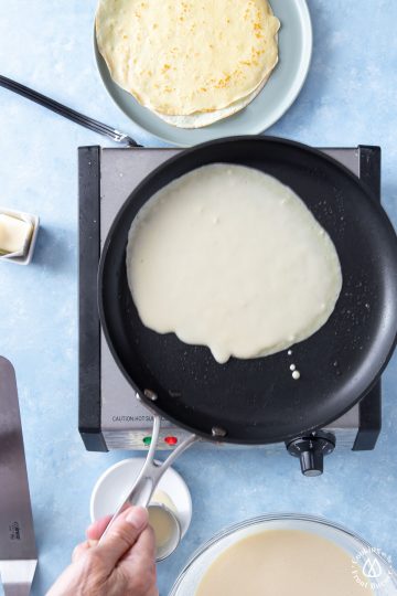 swirling crepe batter in pan