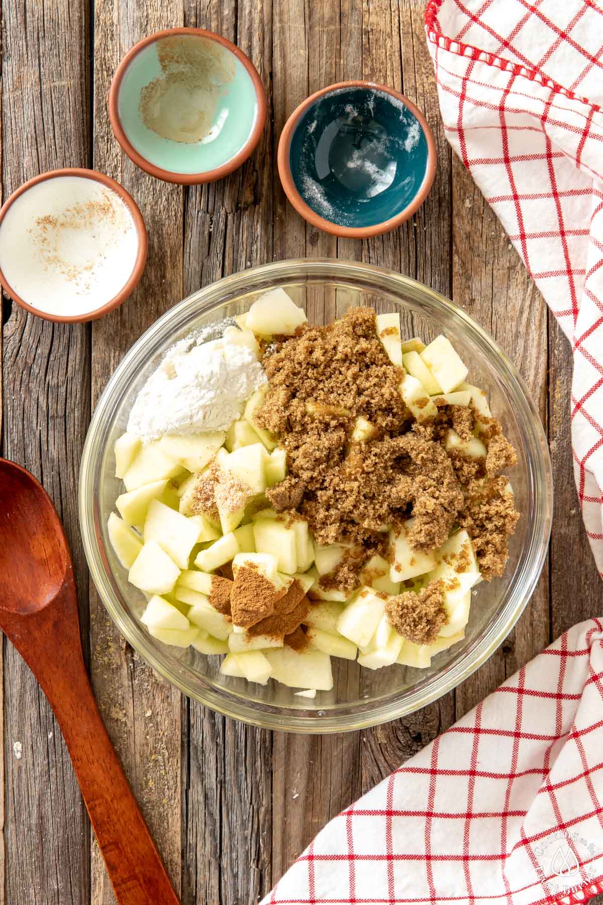 clear bowl with apples, cinnamon, brown sugar, flour