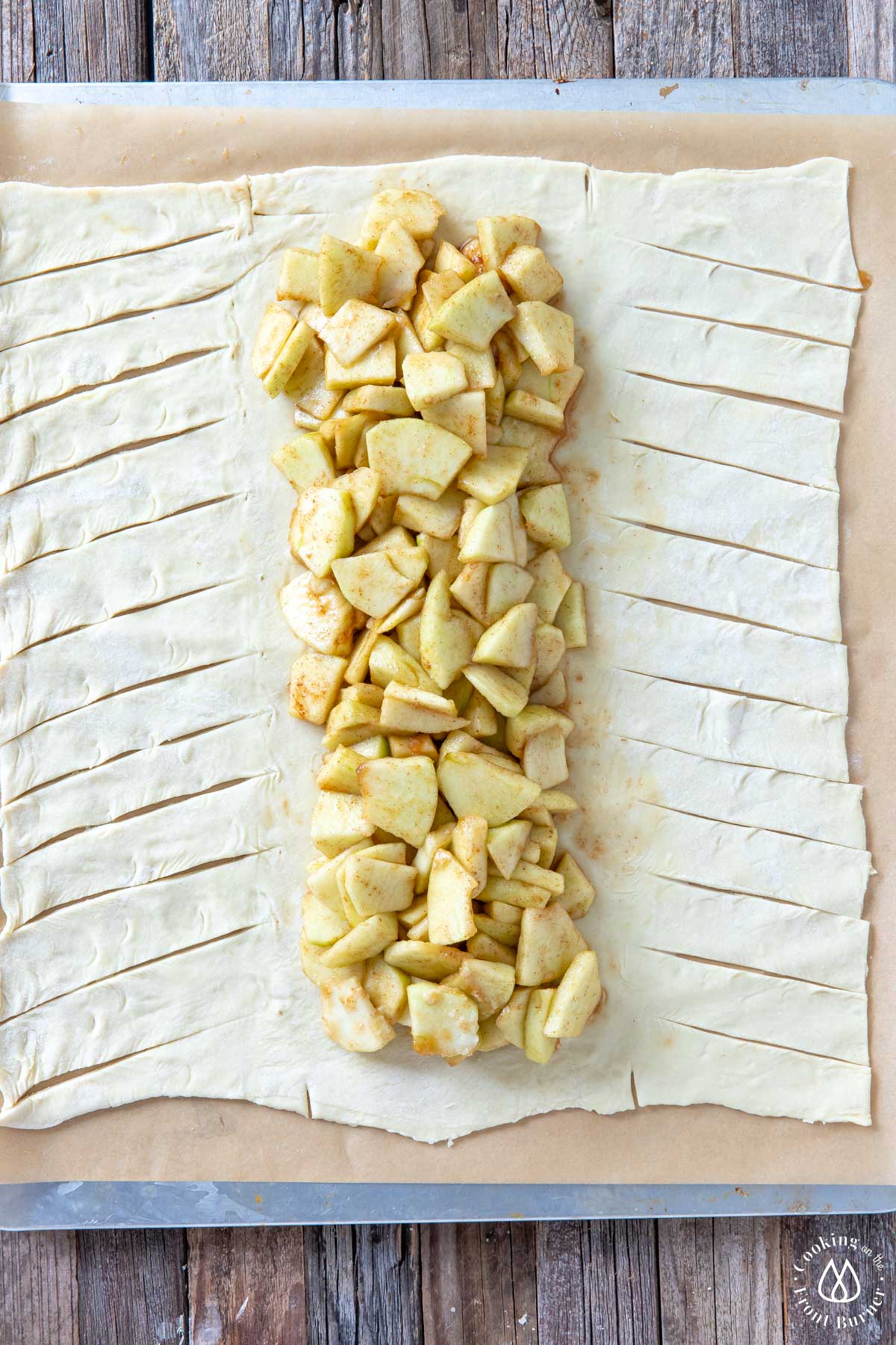 puff pastry on parchment paper with apples down the middle