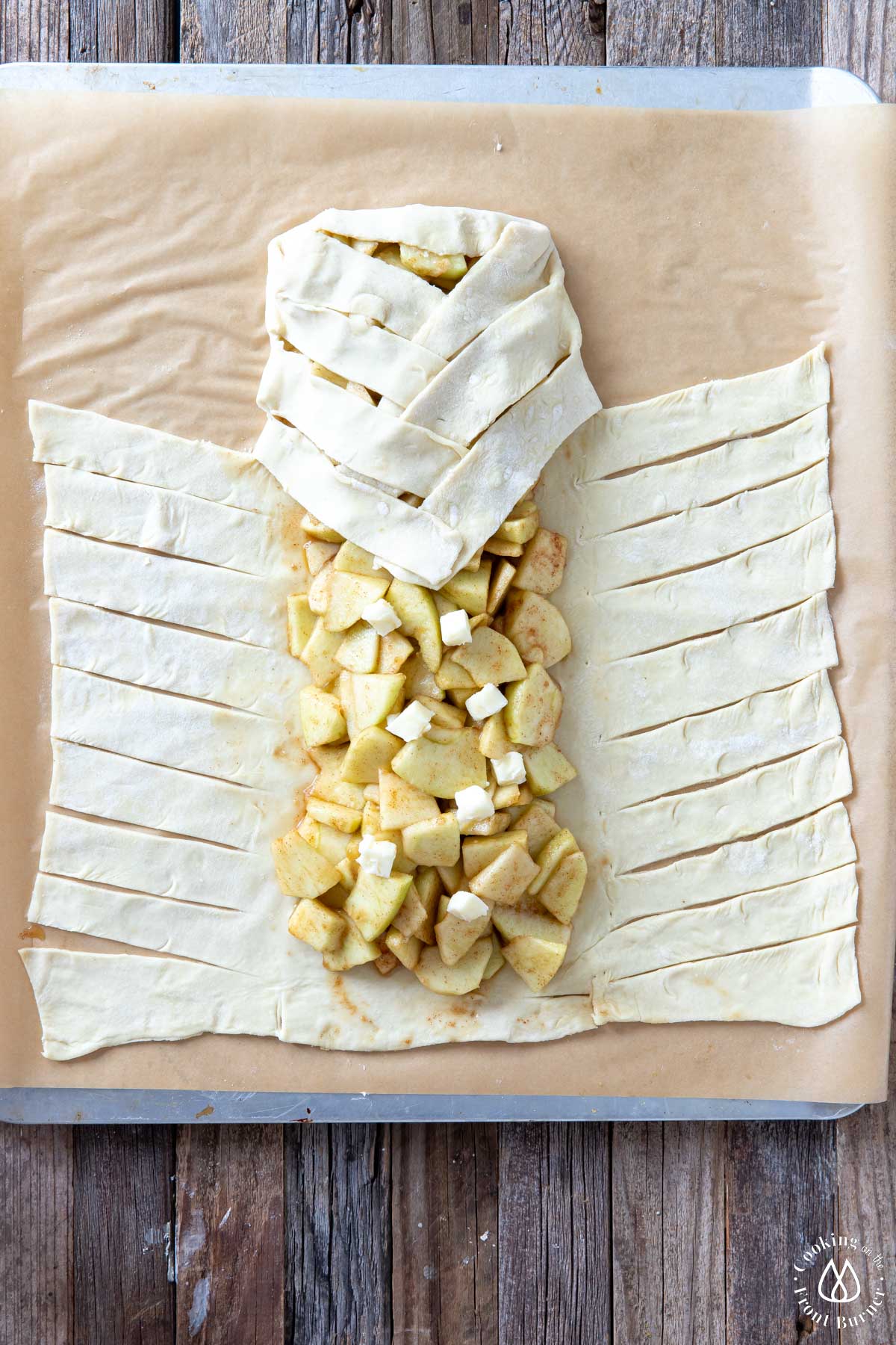 braiding dough strips over apple mixture