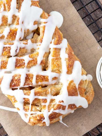 apple strudel with vanilla glaze on parchment paper