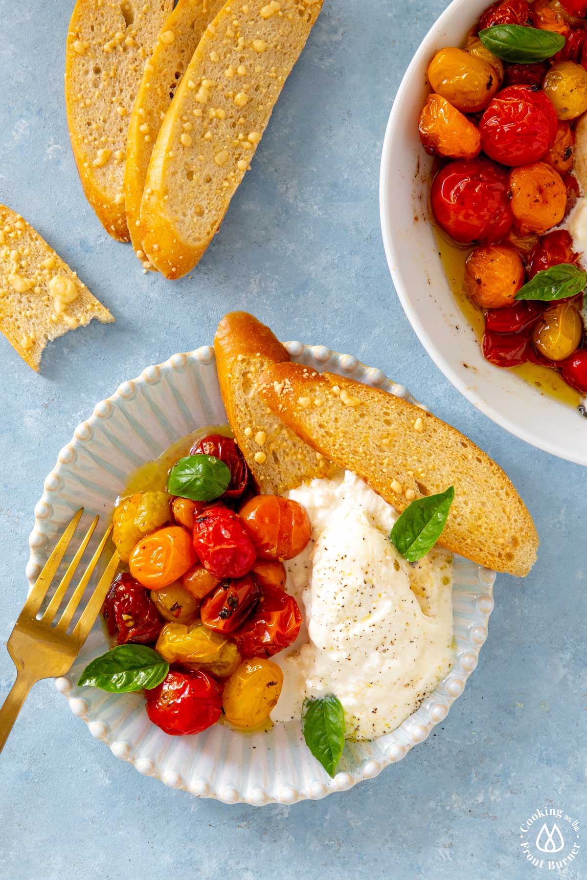 small plate with a serving of roasted tomatoes and burrata